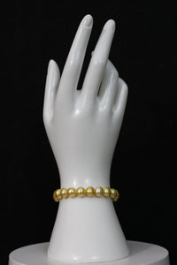 Gold colored cultured button pearl bracelet single strand with 14 karat gold clasp.  (Free shipping and taxes).